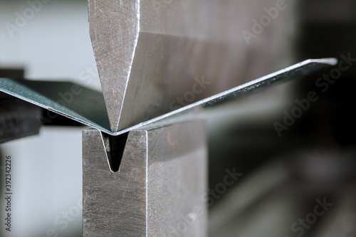 The process of bending sheet metal on a hydraulic bending machine photo