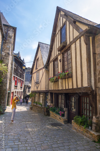 Fototapeta Naklejka Na Ścianę i Meble -  Dinan, France - August 26, 2019: View of historic colombage half-timbered and stone houses on the old cobblestoned street of Dinan, French Brittany