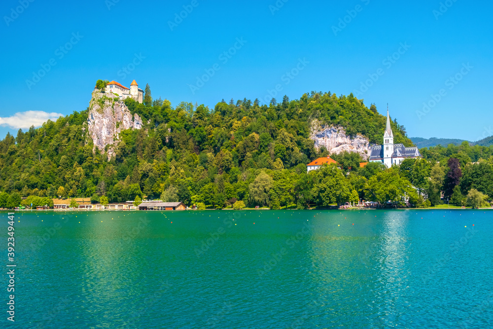 Cozy Lake Bled in summer with the Juliet Alps in the background of the beautiful castle