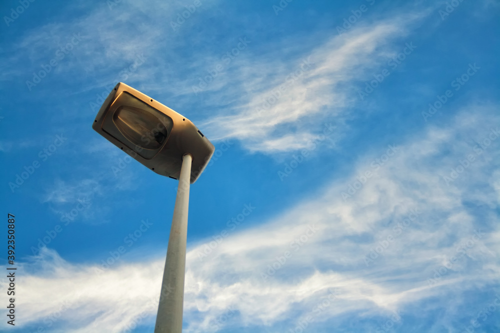 Street lamp with a modern light bulb to save energy on a background of blue sky and beautiful clouds. Street lamp with a modern light bulb to save energy on a background of blue sky and beautiful clouds.