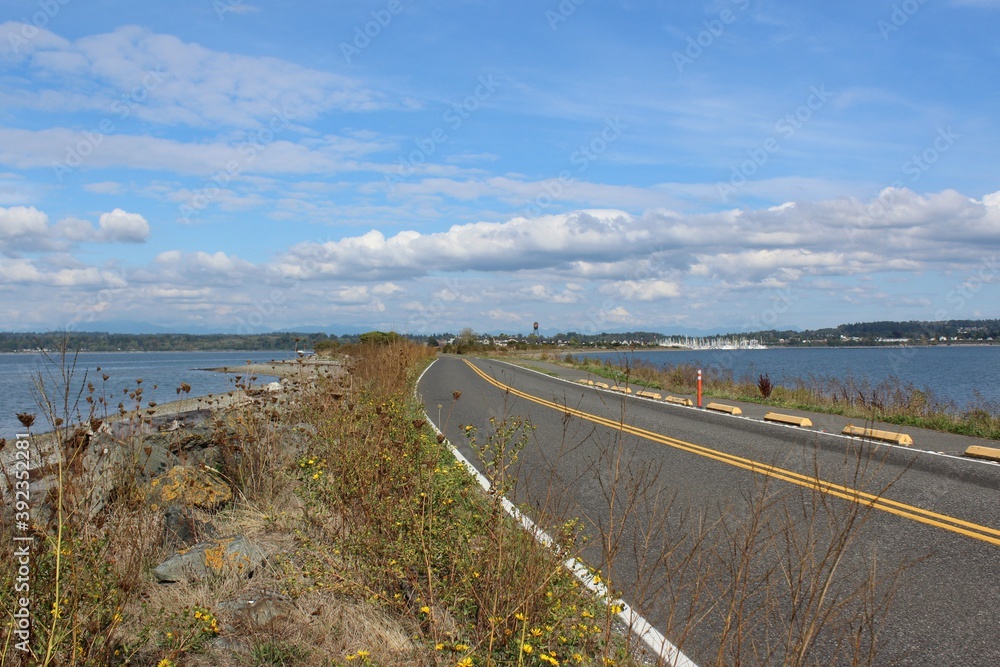 Fototapeta premium Semiahmoo Pkwy and a trail along the Semiahmoo Spit, shore on Semiahmoo Peninsula between Semiahmoo Bay and Drayton Harbor off the coast of Blaine 