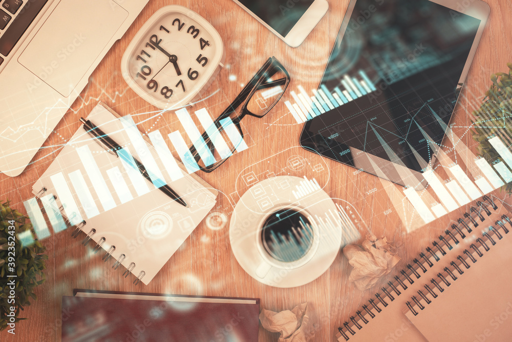Double exposure of financial chart hologram over desktop with phone. Top view. Mobile trade platform concept. Double exposure of financial chart hologram over desktop with phone. Top view. Mobile trade platform concept.