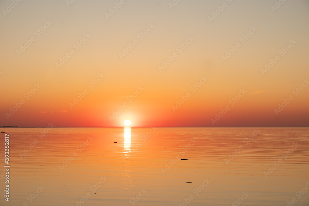 Amazing orange golden sunset over the sea. Summer sunset at the Baltic sea, Europe.