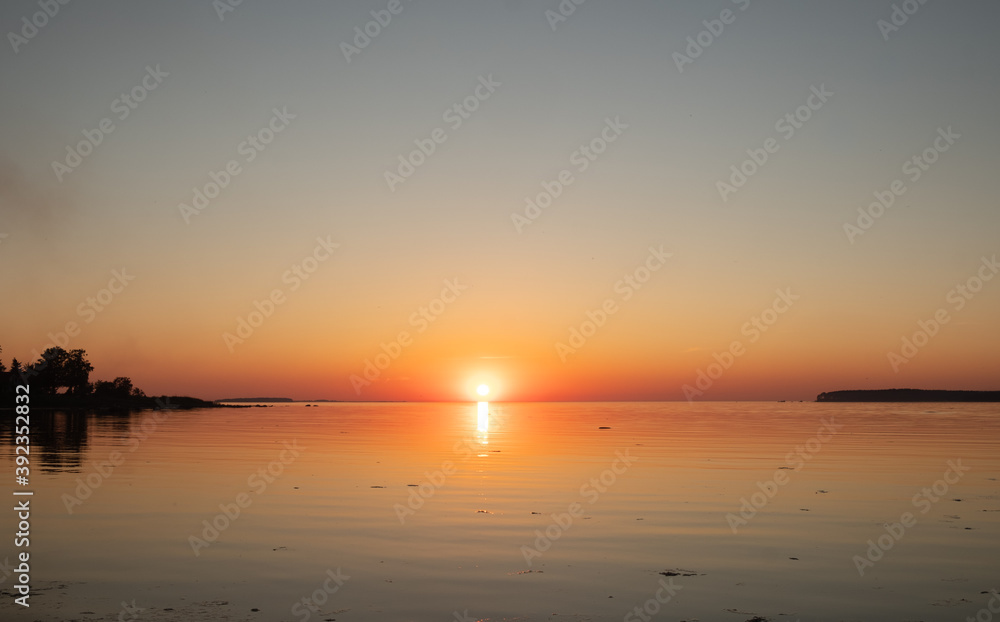 Amazing orange golden sunset over the sea. Summer sunset at the Baltic sea, Europe.