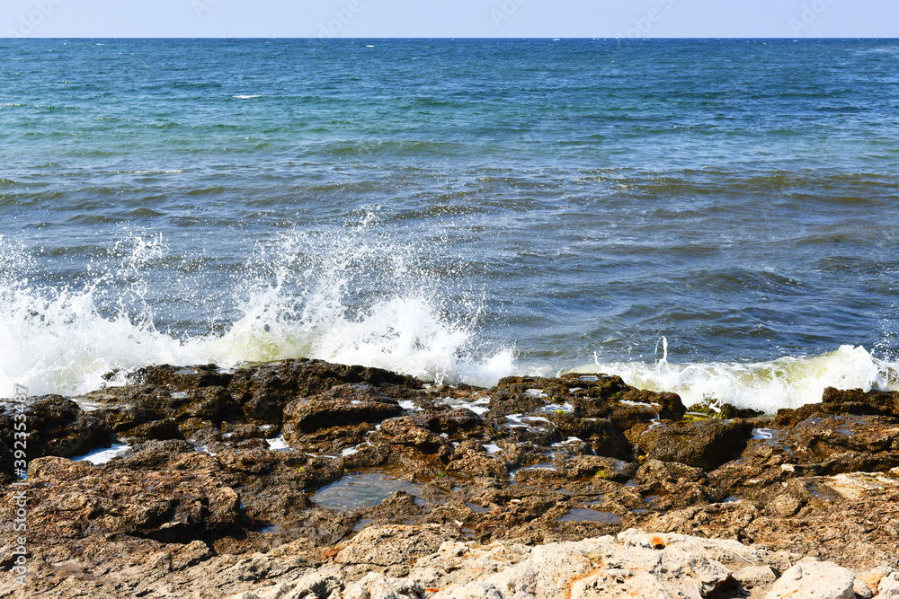 Beautiful bursts of foam waves on the seashore. White foam and bubbles beat against the rocky beach. Turquoise waves. Beautiful bursts of foam waves on the seashore. White foam and bubbles beat against the rocky beach. Turquoise waves.