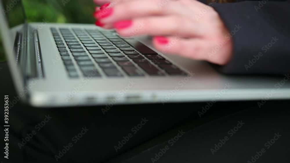 Business woman typing on portable computer. Close up of female fingers typewriting a document the laptop Business woman typing on portable computer. Close up of female fingers typewriting a document the laptop