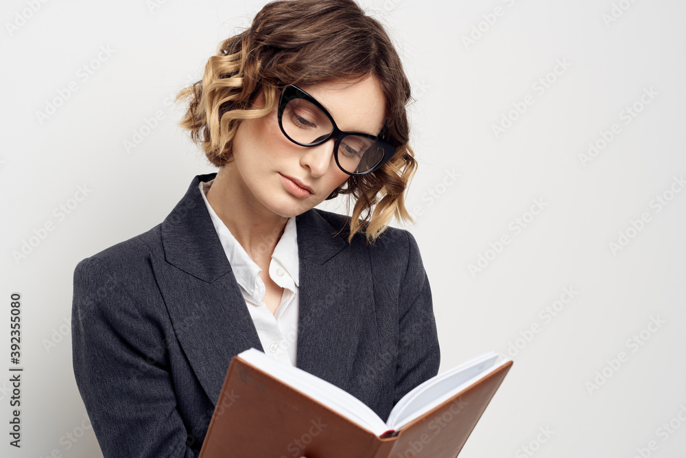 Business woman in a classic suit with a notebook in her hand and glasses on her face Copy Space Business woman in a classic suit with a notebook in her hand and glasses on her face Copy Space