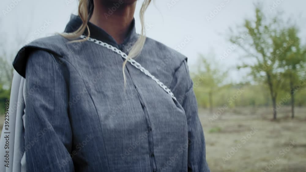 Scared young blonde medieval princess is holding a sword and looking around, 4k Scared young blonde medieval princess is holding a sword and looking around, 4k
