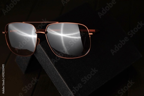 Brown Sunglass on the black case with dark background	