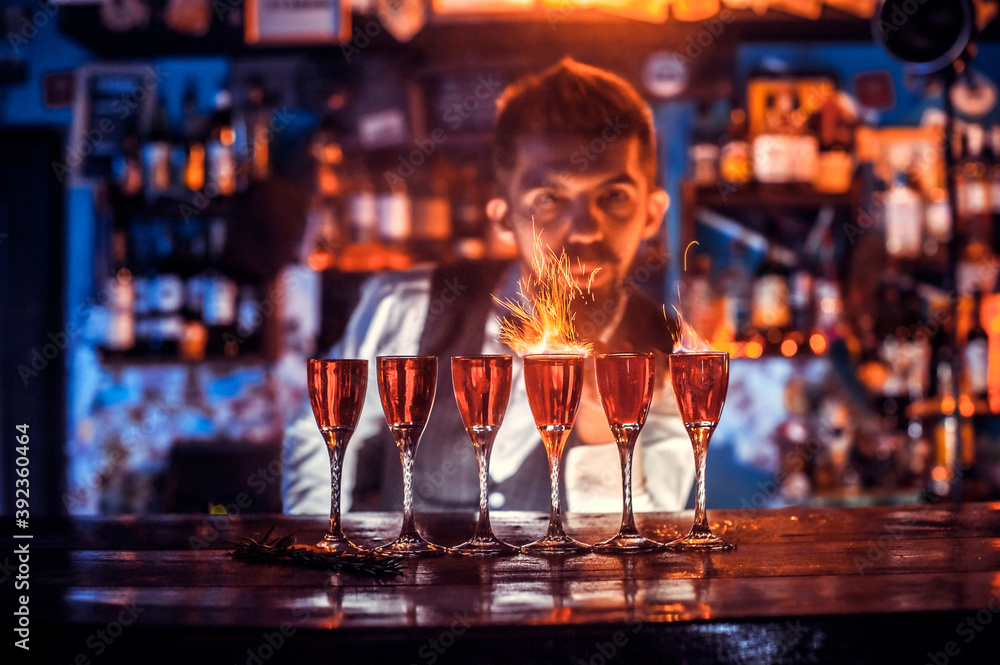 Portrait of bartending creates a cocktail behind the bar