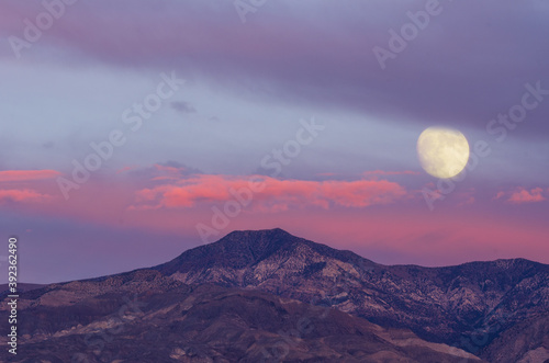 Moonrise and colorful dusk clouds in Death Valley, California.