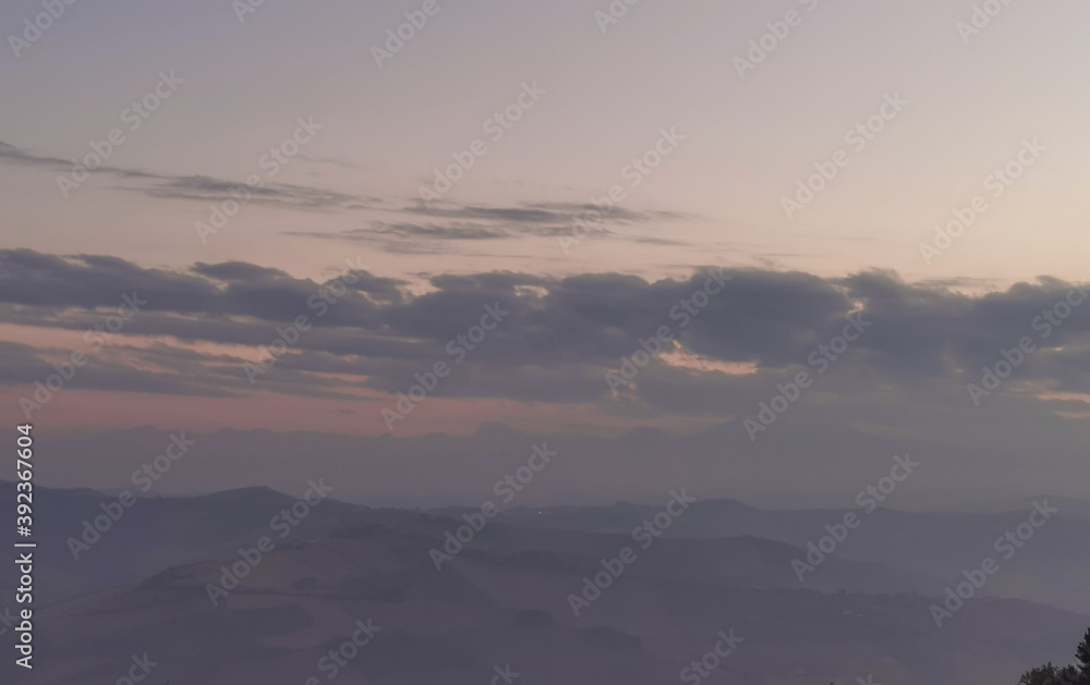 Obraz premium Tramonto grigio azzurro tra nebbia e foschia sulle valli e sui monti Appennini