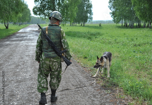 JURGA, SIBERIA, RUSSIA - JUNE 6,2011:Military dog handler with a Sheepdog to search for explosives