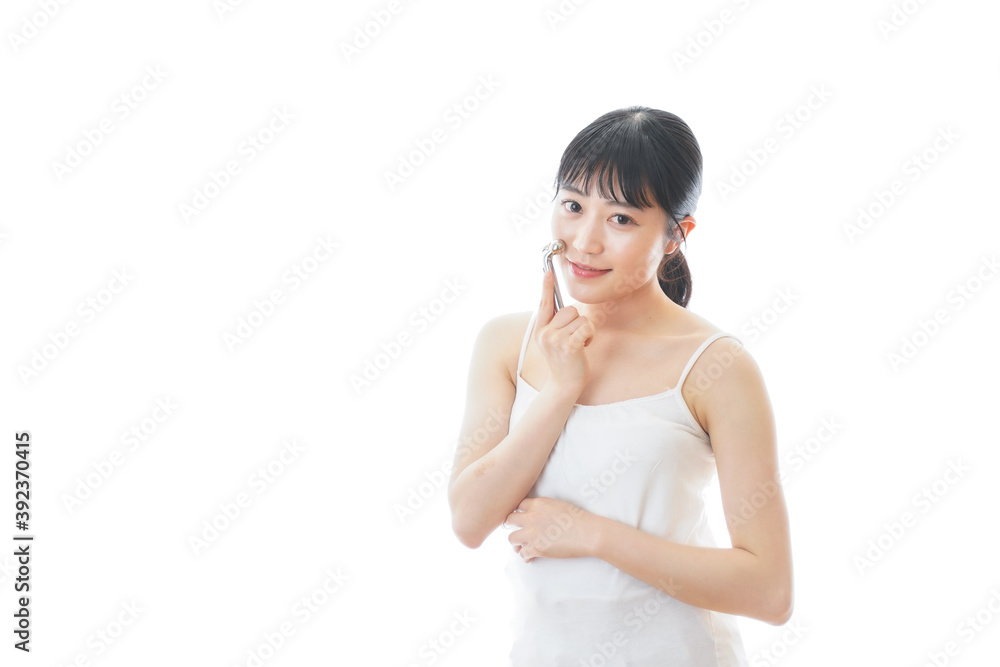 かっさで肌をマッサージをする若い女性 かっさで肌をマッサージをする若い女性