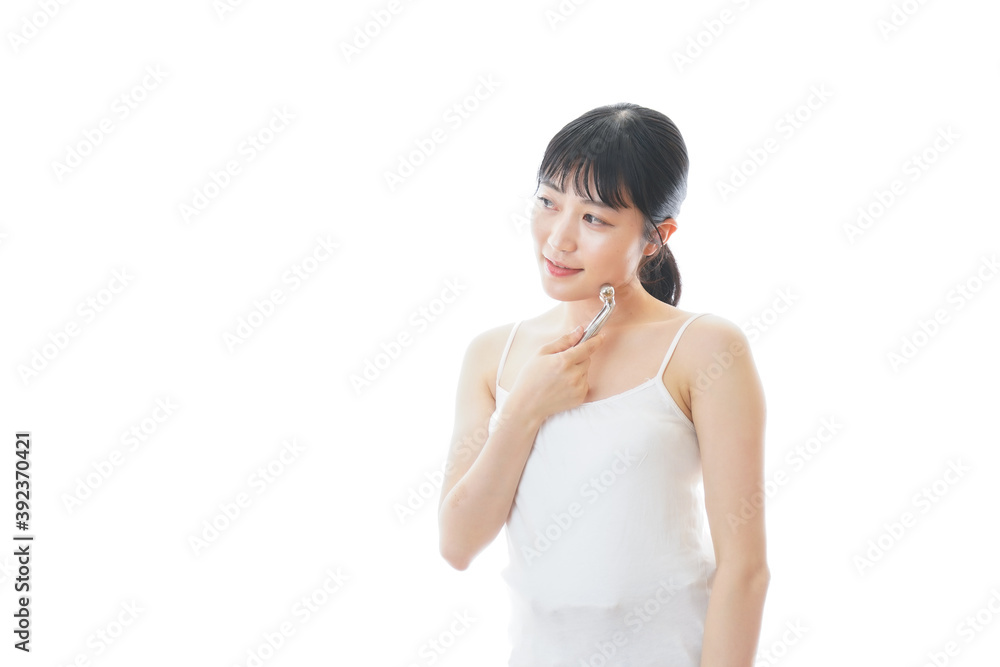かっさで肌をマッサージをする若い女性 かっさで肌をマッサージをする若い女性
