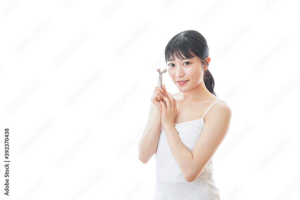 かっさで肌をマッサージをする若い女性 かっさで肌をマッサージをする若い女性