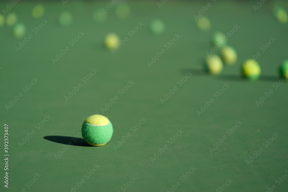 close up many tennis ball on tennis court ground under sunlight. Blur background