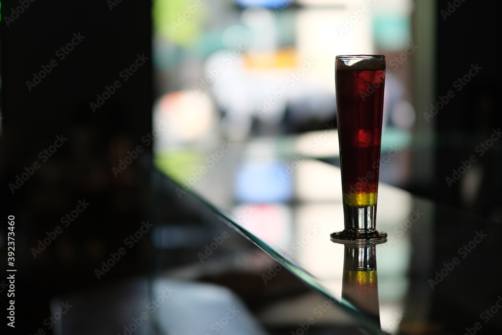close up a glass of cocktail on glass bar counter with colorful bokeh close up a glass of cocktail on glass bar counter with colorful bokeh