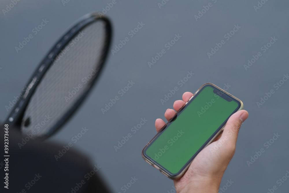 Smart Racket With Phone over shoulder view of people holding green screen smart phone while ...