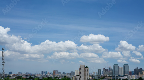 Outdoor white fluffy clouds on blue sky above city building