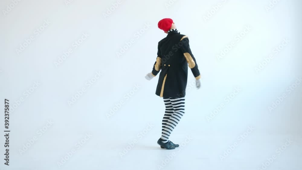 Male mime performer in bright clothing and beret is dancing alone and gesturing looking at camera on white background. Pantomime show and creativity concept. Male mime performer in bright clothing and beret is dancing alone and gesturing looking at camera on white background. Pantomime show and creativity concept.