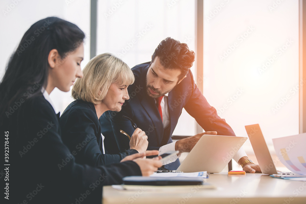 business partners discussing documents and ideas at meeting, Businesspeople using laptop at conference table business partners discussing documents and ideas at meeting, Businesspeople using laptop at conference table