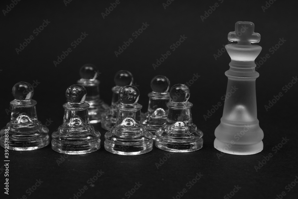 Obraz premium glass chess pawn and king piece above shot on black background. challenge and competition concept