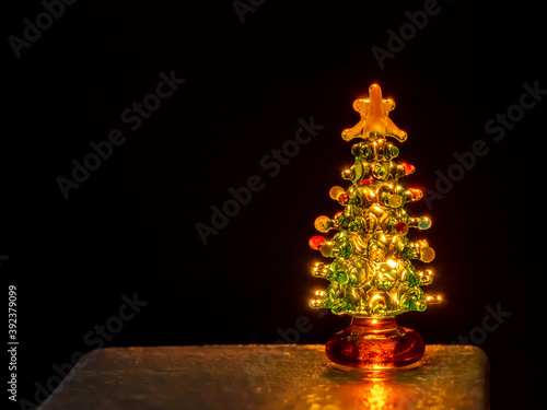 Glass Christmas tree back lit by candle light