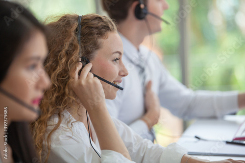 Call center worker accompanied by her team. Asian woman working in call center office as a telemarketer  customer support operator at work