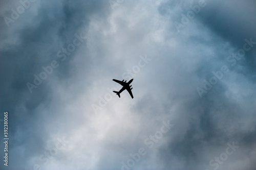 silhouette of jet air craft passenger plane in cloudy sky with copy space