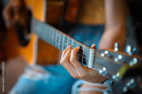 A woman's hand close-up picture playing acoustic guitar