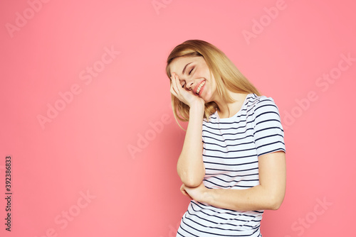 Cheerful woman striped t-shirt lifestyle emotions and gestures with hands pink background