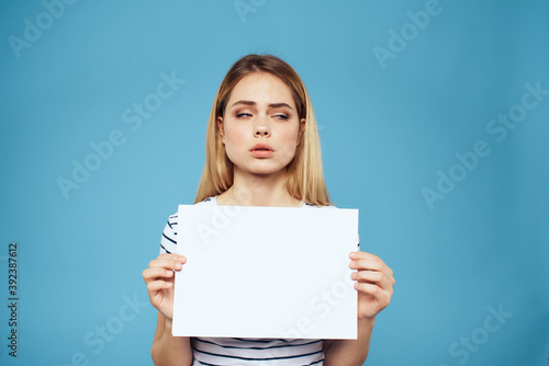 Emotional woman holding a sheet of paper in her hands lifestyle close-up blue background Copy Space