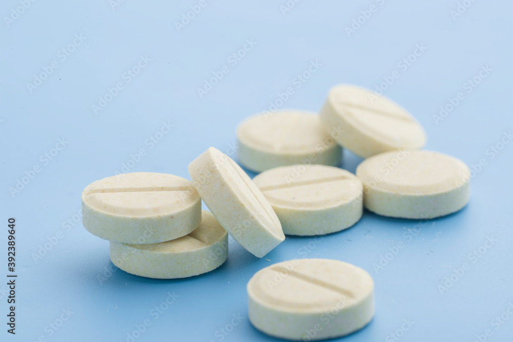 Pills are scattered on a blue background. Pills are scattered on a blue background.