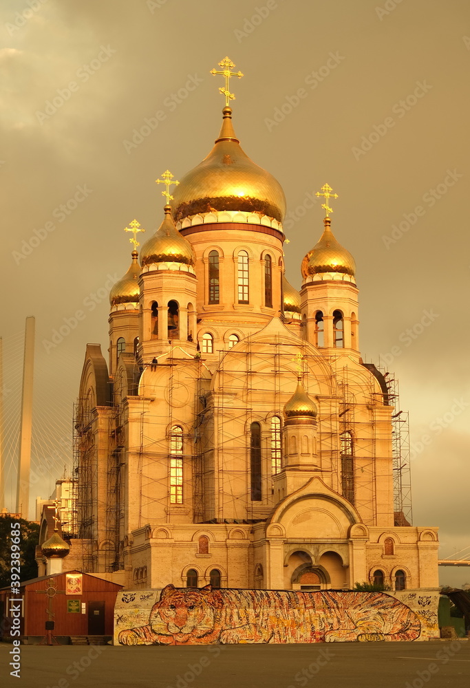 Obraz premium Catholic church with a golden dome on an orange sky background