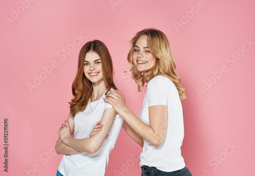 Cute girlfriends socializing lifestyle Friendship cropped view pink background