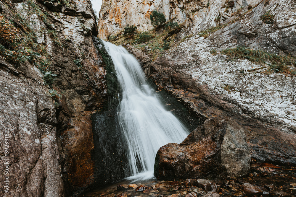 Small waterfall in mountain. Hiking and eco tourism in Caucasus mountain. Travel destinations.