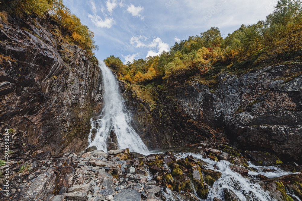 Small waterfall in mountain. Hiking and eco tourism in Caucasus mountain. Travel destinations.