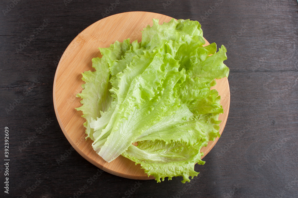 fresh lettuce leaves on a dark wooden background fresh lettuce leaves on a dark wooden background