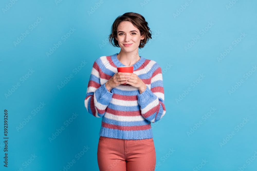 Photo portrait of cute smiling girl keeping red mug wearing casual clothes isolated on bright blue color background Photo portrait of cute smiling girl keeping red mug wearing casual clothes isolated on bright blue color background