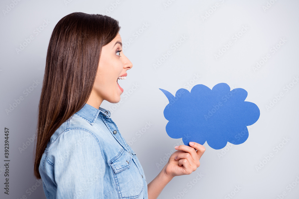 Profile side photo of pretty funky young lady hold cloud talk card speak secret isolated on grey color background Profile side photo of pretty funky young lady hold cloud talk card speak secret isolated on grey color background