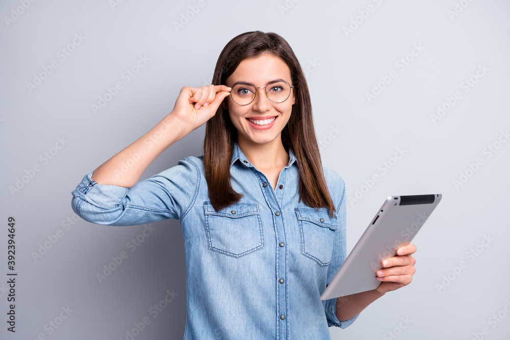 Photo of attractive lovely brown haired woman hold tablet adjust glasses university student isolated on grey color background Photo of attractive lovely brown haired woman hold tablet adjust glasses university student isolated on grey color background