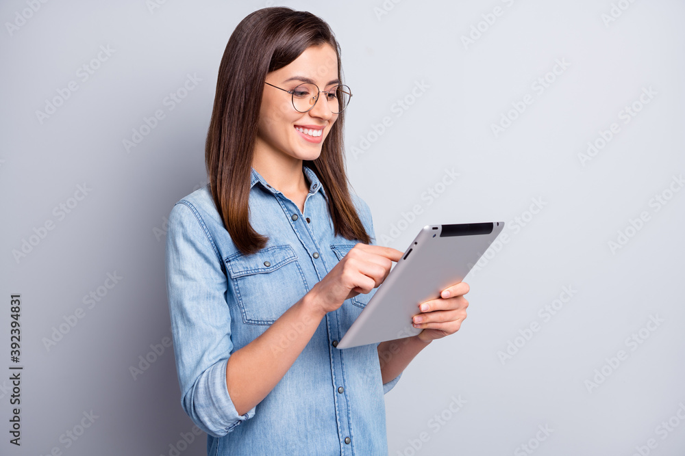 Profile portrait of optimistic cute long hairdo girl writing tablet wear spectacles blue cloth isolated on grey background Profile portrait of optimistic cute long hairdo girl writing tablet wear spectacles blue cloth isolated on grey background