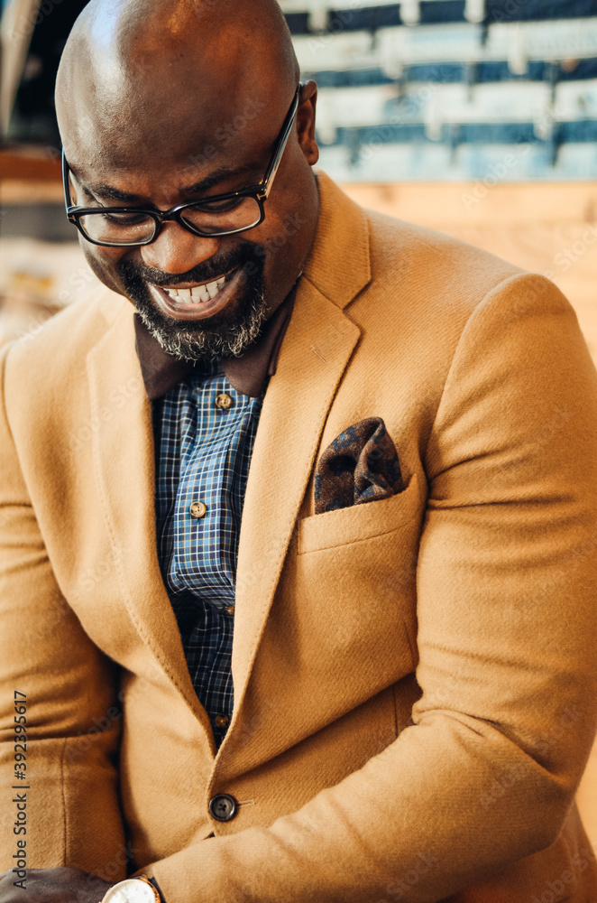 Portrait of confident African American businessman in glasses and tan ...