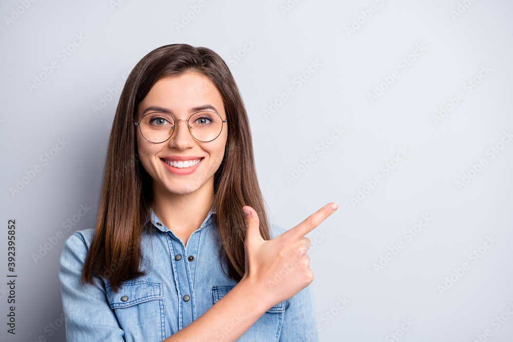 Close up photo of adorable person indicate finger empty space banner isolated on grey color background Close up photo of adorable person indicate finger empty space banner isolated on grey color background