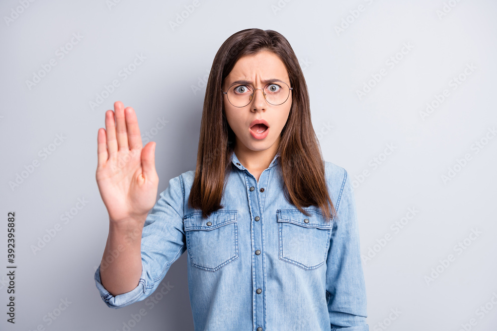 Photo of furious young person show arm prohibition symbol open mouth isolated on grey color background Photo of furious young person show arm prohibition symbol open mouth isolated on grey color background
