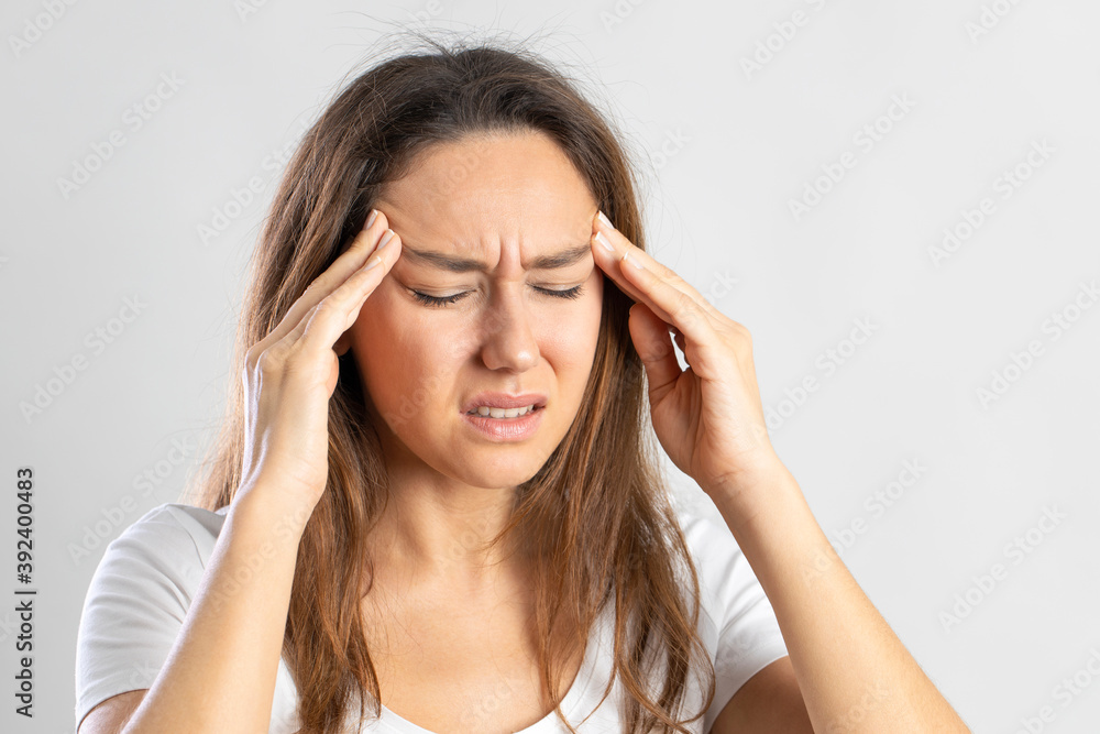 Girl suffering migraine on isolated gray background Girl suffering migraine on isolated gray background