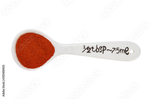 Photography Closeup shot of a half tablespoon of ground paprika isolated on a white backgrou