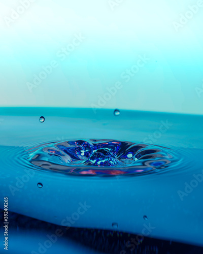 Plusk na gładkiej powierzchni w niebieskim odcieniu wody