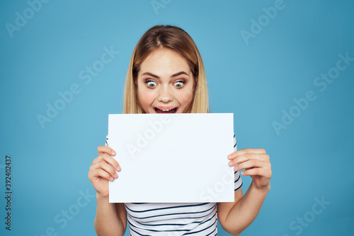 Woman holding sheet of paper striped T-shirt Copy Space cropped view blue background